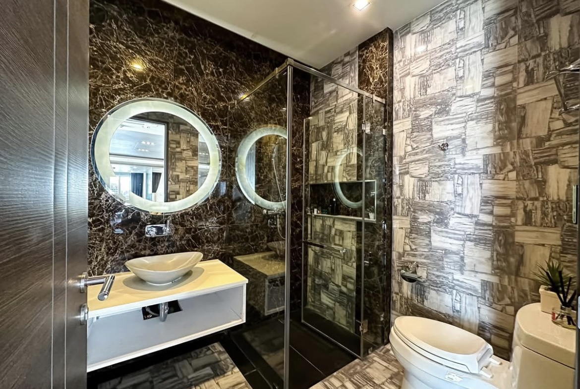 Luxury 3-bedroom penthouse for rent near BTS Asoke, 240 sqm with large walk-in closet, modern kitchen, office space, city view balconies, and premium facilities. 150,000 THB/month.