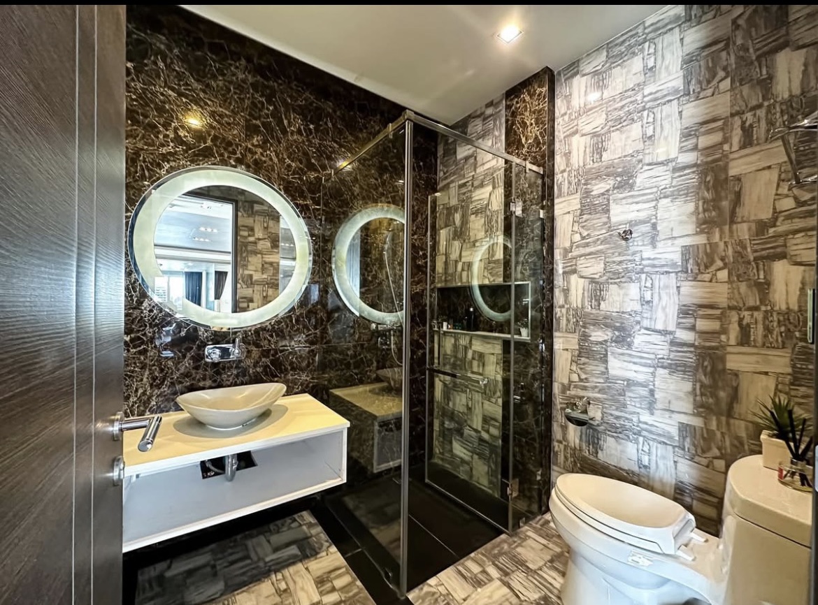 Luxury 3-bedroom penthouse for rent near BTS Asoke, 240 sqm with large walk-in closet, modern kitchen, office space, city view balconies, and premium facilities. 150,000 THB/month.